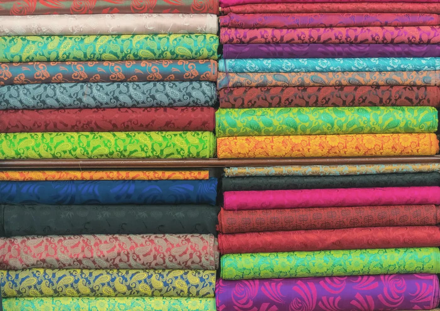 Folded cottons in many colours stacked on shelves