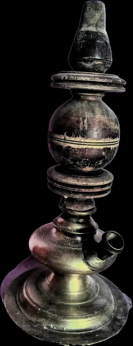 An old lamp of turned wood and brass with a spout near its base